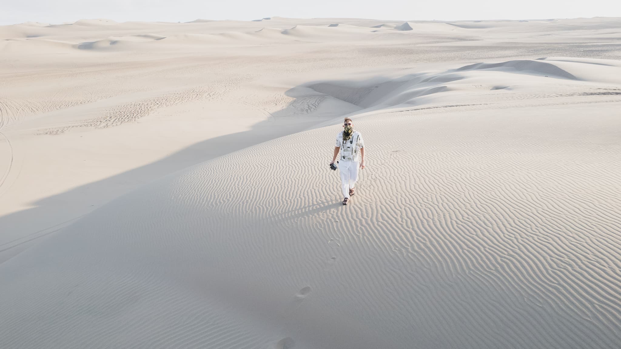 A person walking alone across vast desert dunes, symbolizing clarity, discipline, and intentional progress.